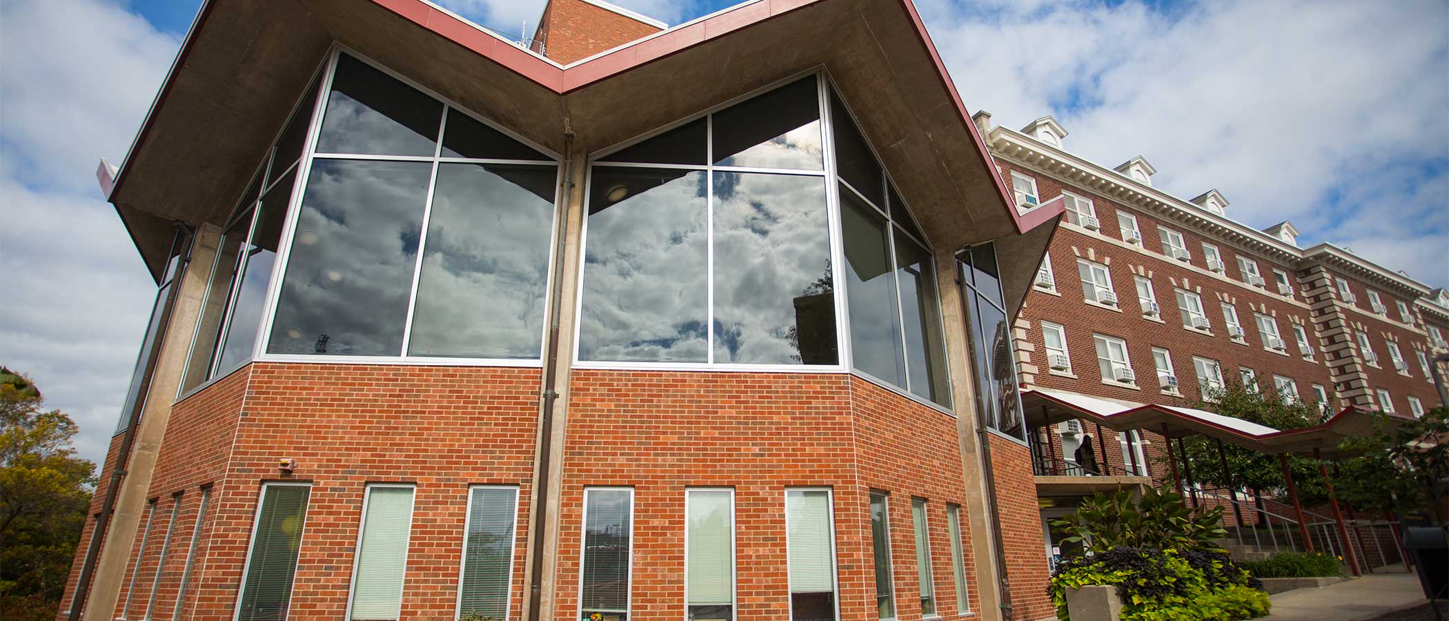 A window outside of Currier Hall, reflecting a blue sky and clouds